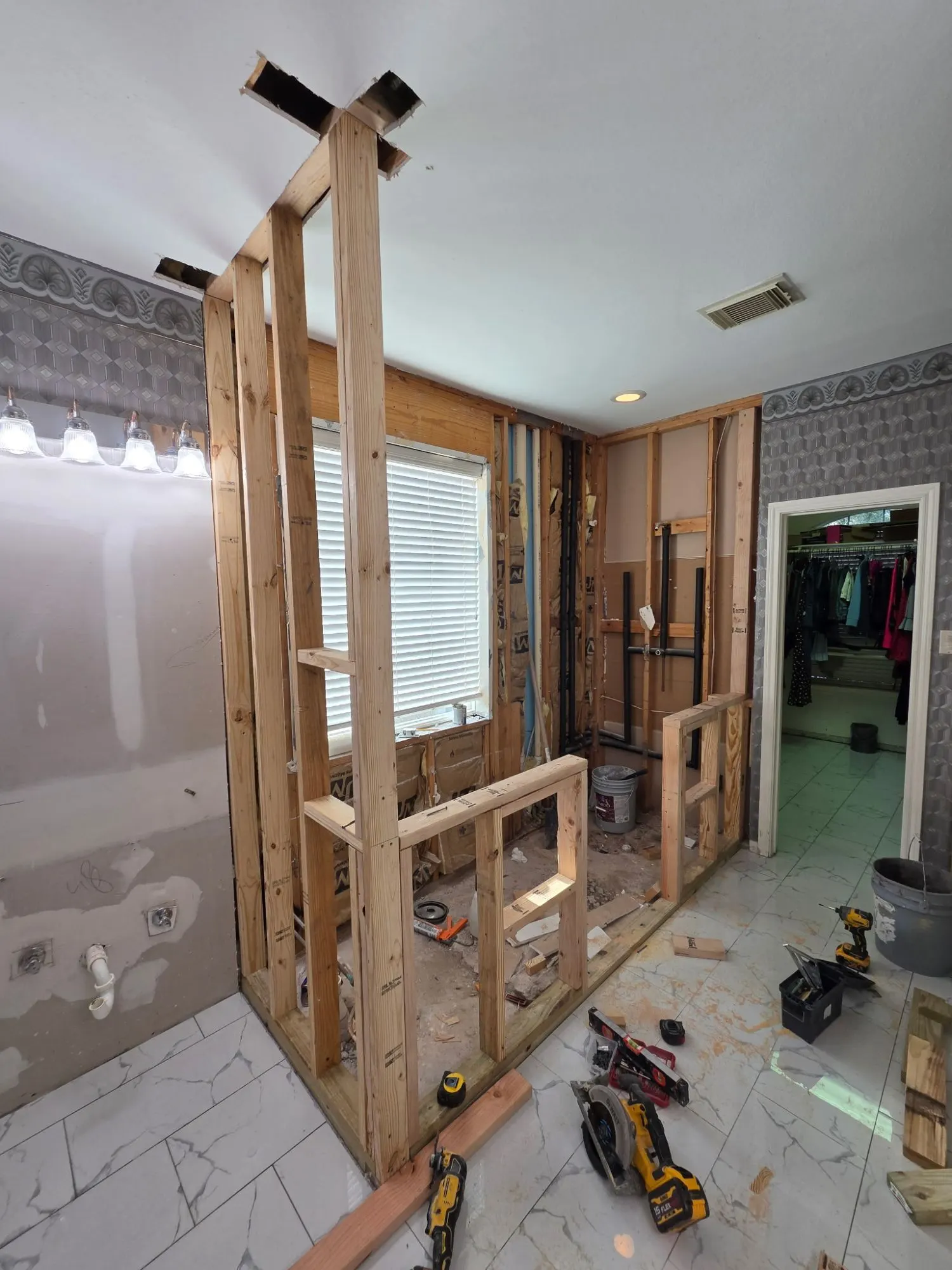 Before: primary bath stripped to the studs, with new framing for a walk-in shower